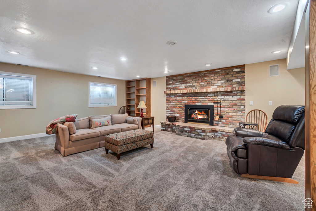 Carpeted living area featuring recessed lighting and a brick fireplace