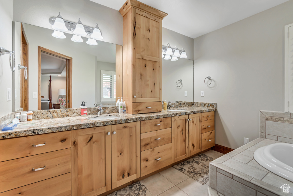 Ensuite bathroom featuring double vanity, a bath, and tile patterned floors