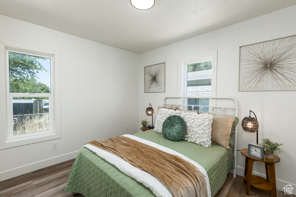 Bedroom with multiple windows and wood finished floors