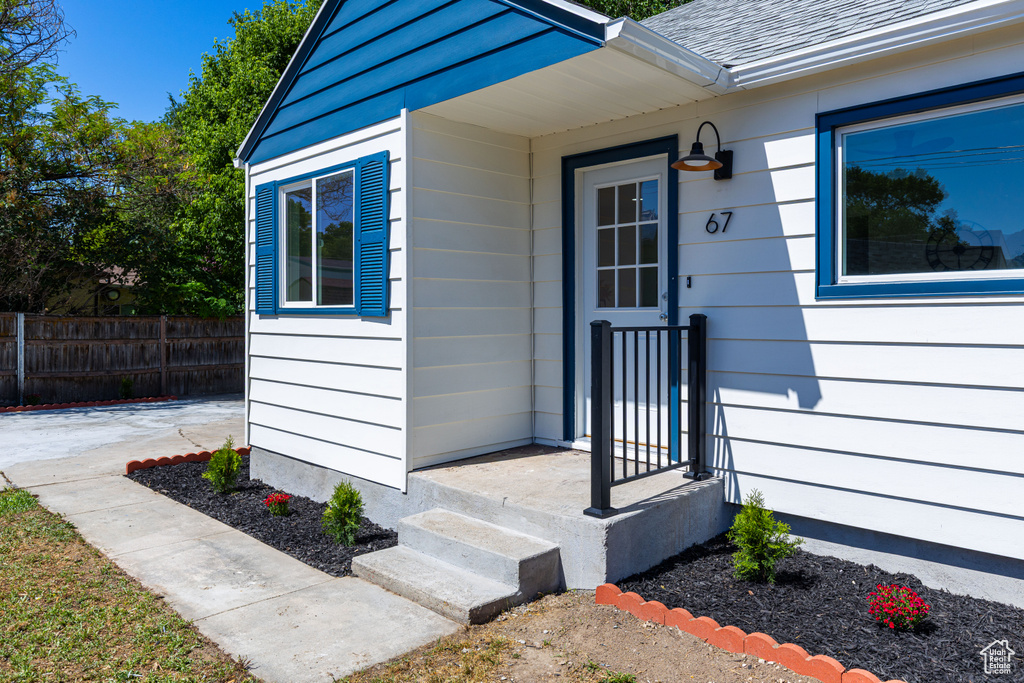 Entrance to property with a shingled roof