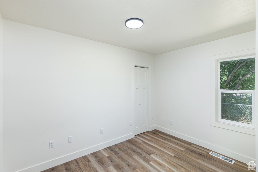 Unfurnished room with wood finished floors and baseboards