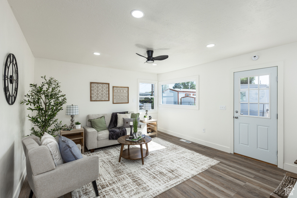 Living area featuring plenty of natural light, dark wood-style flooring, a ceiling fan, and recessed lighting