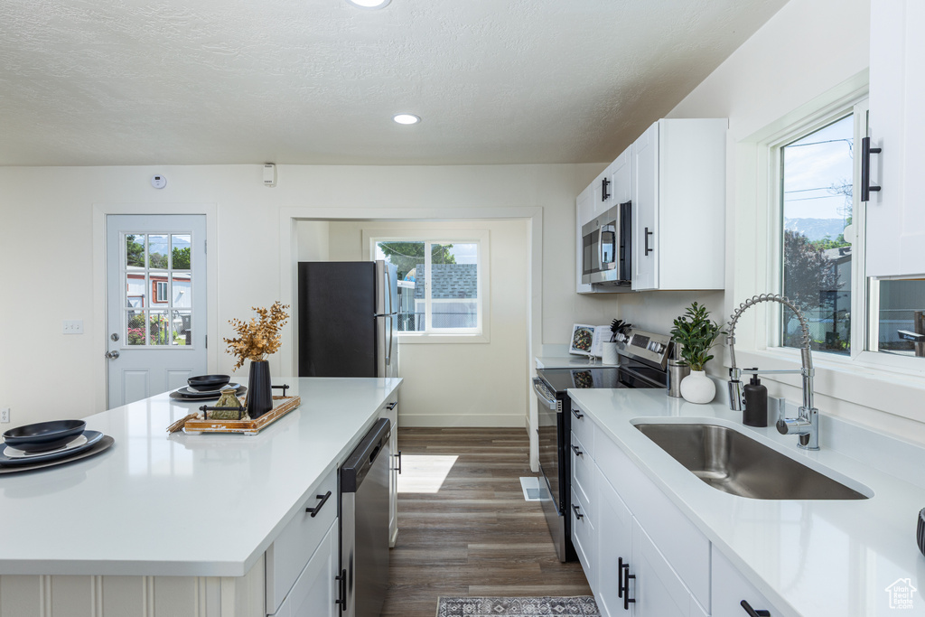 Kitchen with stainless steel appliances, recessed lighting, dark wood-style floors, healthy amount of natural light, and a textured ceiling