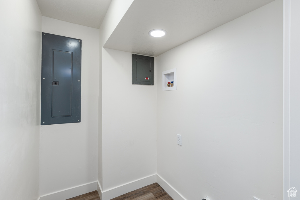 Laundry room featuring electric panel, dark wood finished floors, and hookup for a washing machine