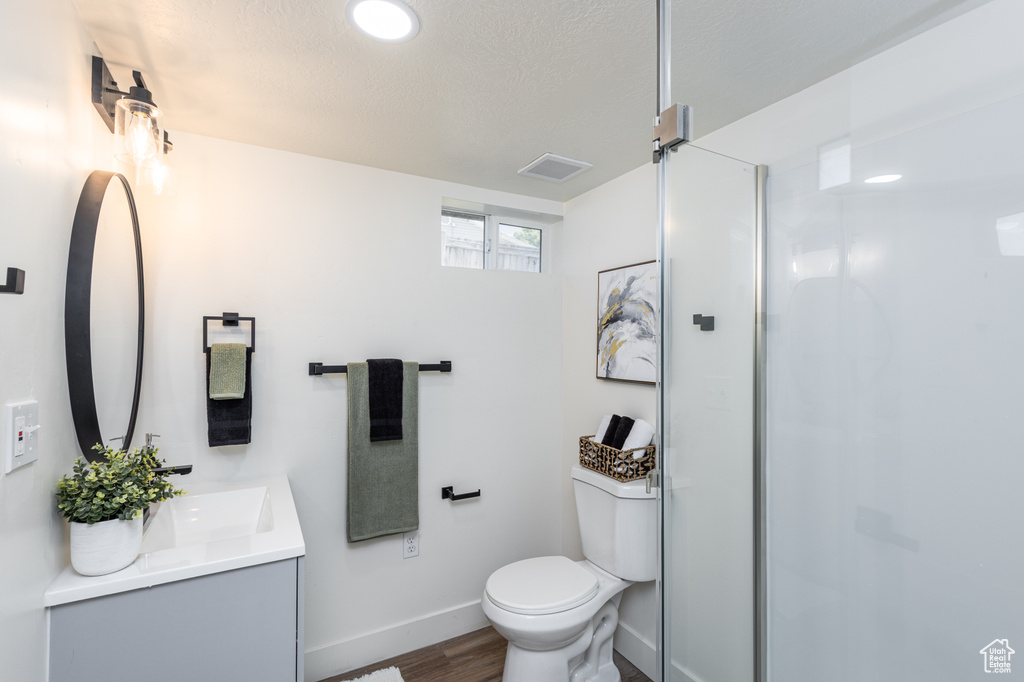 Full bath with vanity, wood finished floors, and a shower