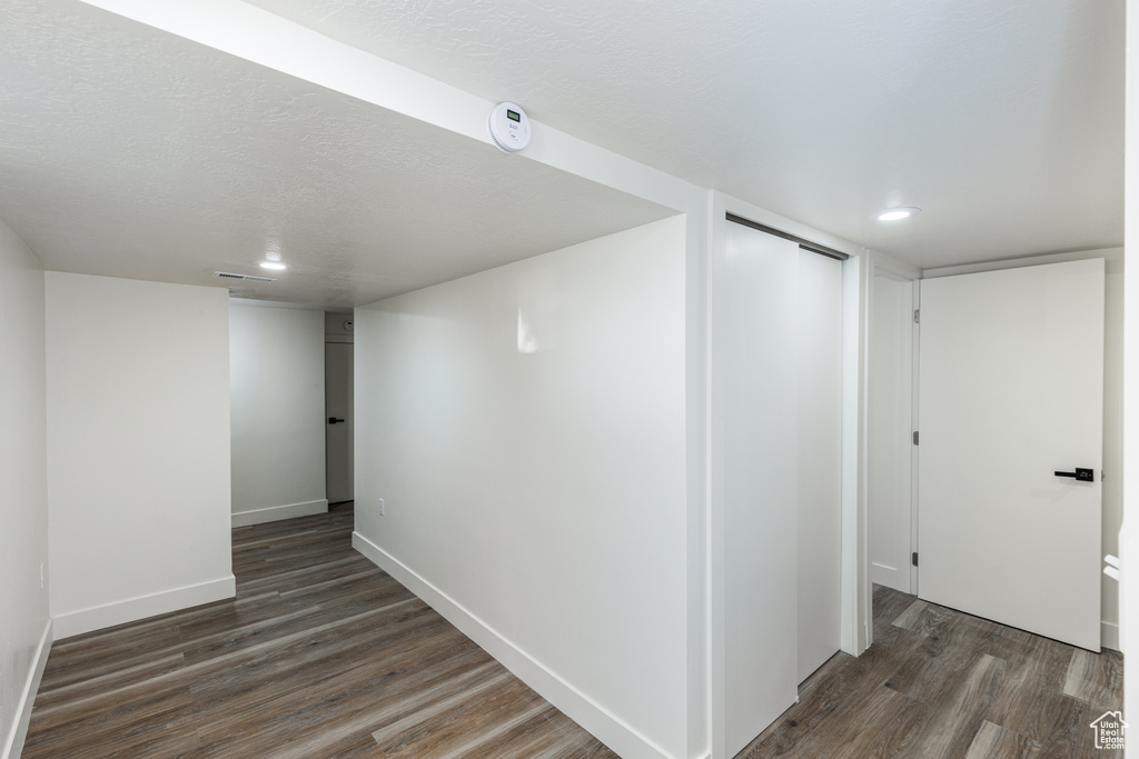 Finished below grade area featuring wood finished floors and a textured ceiling
