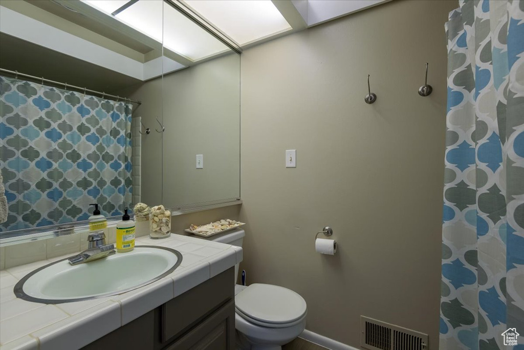 Full bath featuring vanity, toilet, and a shower with curtain