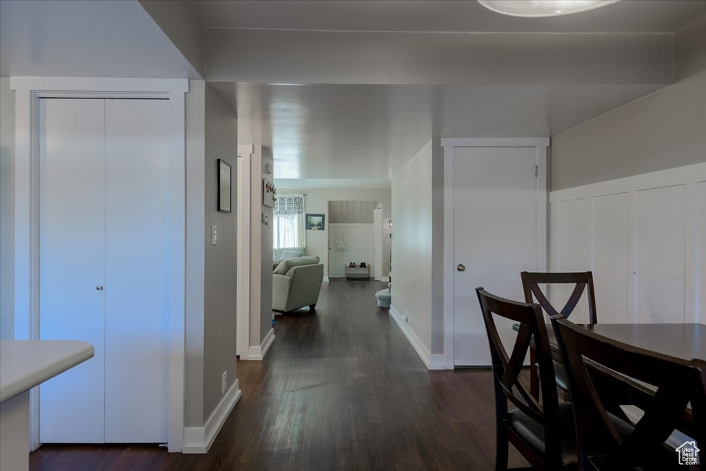Corridor featuring dark wood-style flooring and baseboards