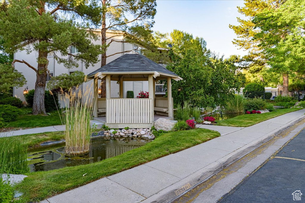 View of property\\\\\\\'s community featuring a gazebo and a garden pond