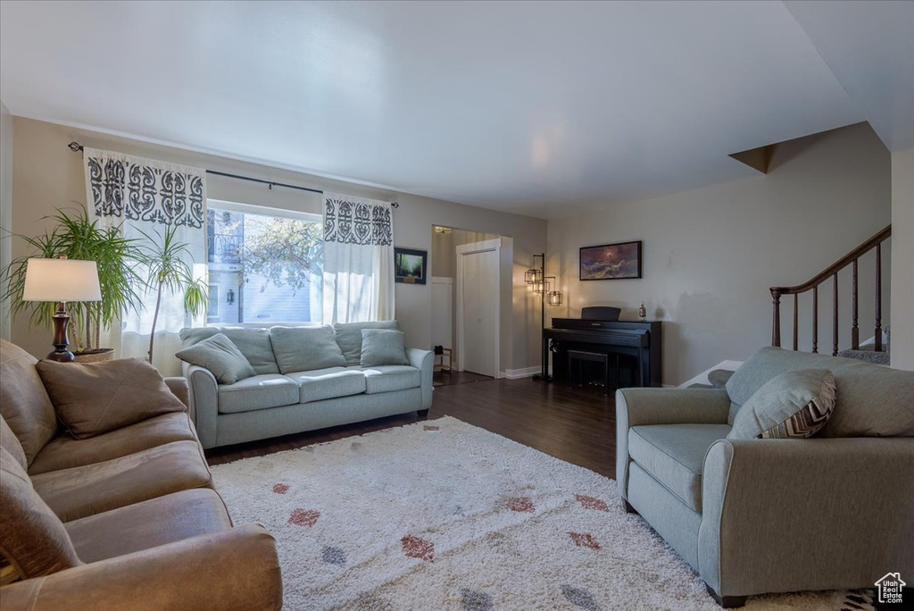 Living area featuring wood finished floors, stairway, and baseboards
