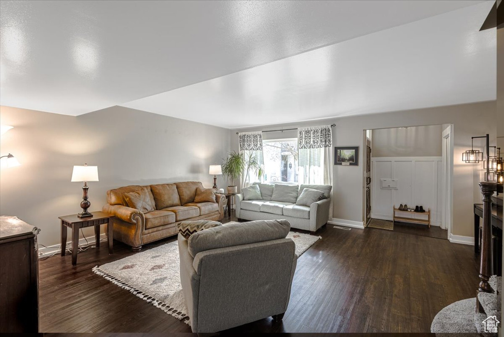 Living area with dark wood-style floors and baseboards