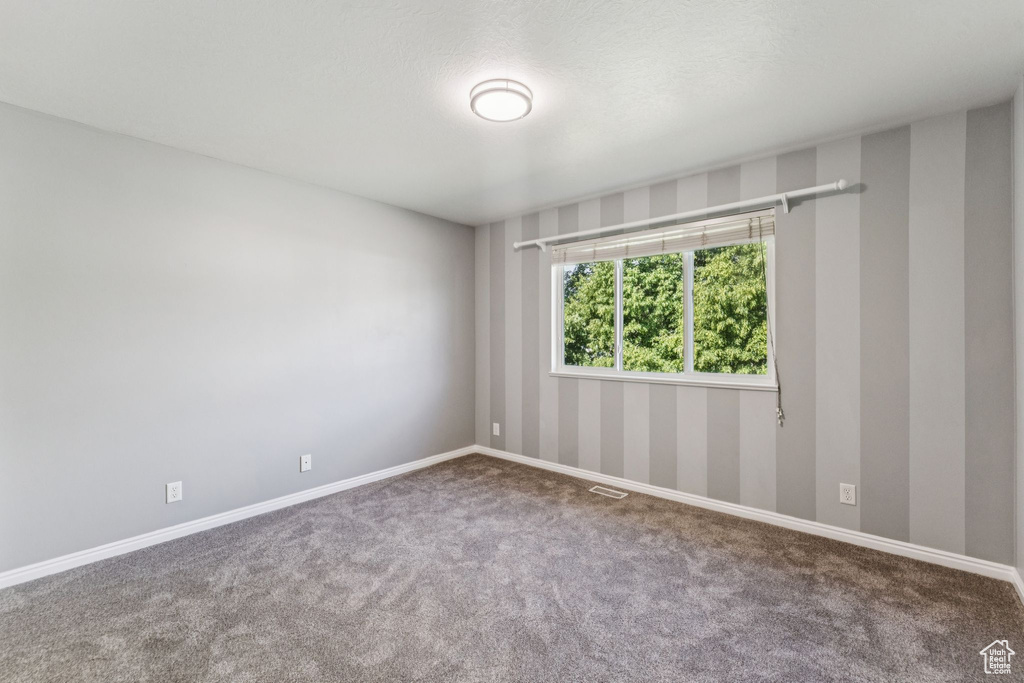 Empty room featuring carpet floors and baseboards