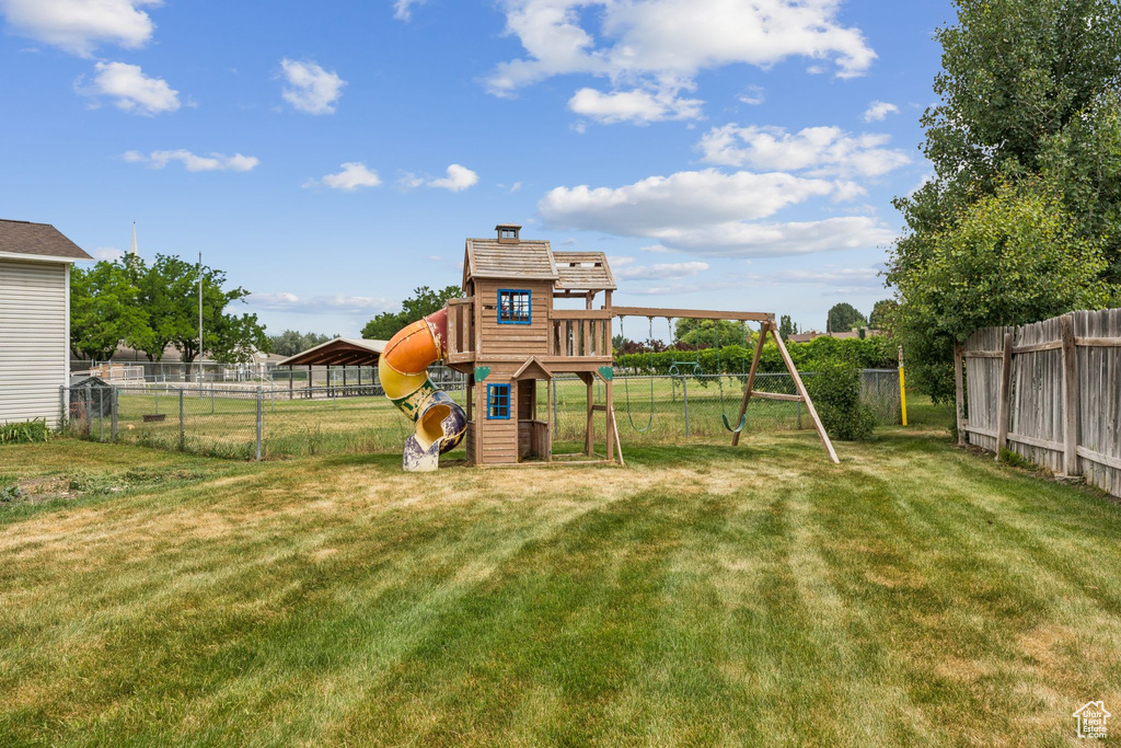 Fenced backyard featuring a playground