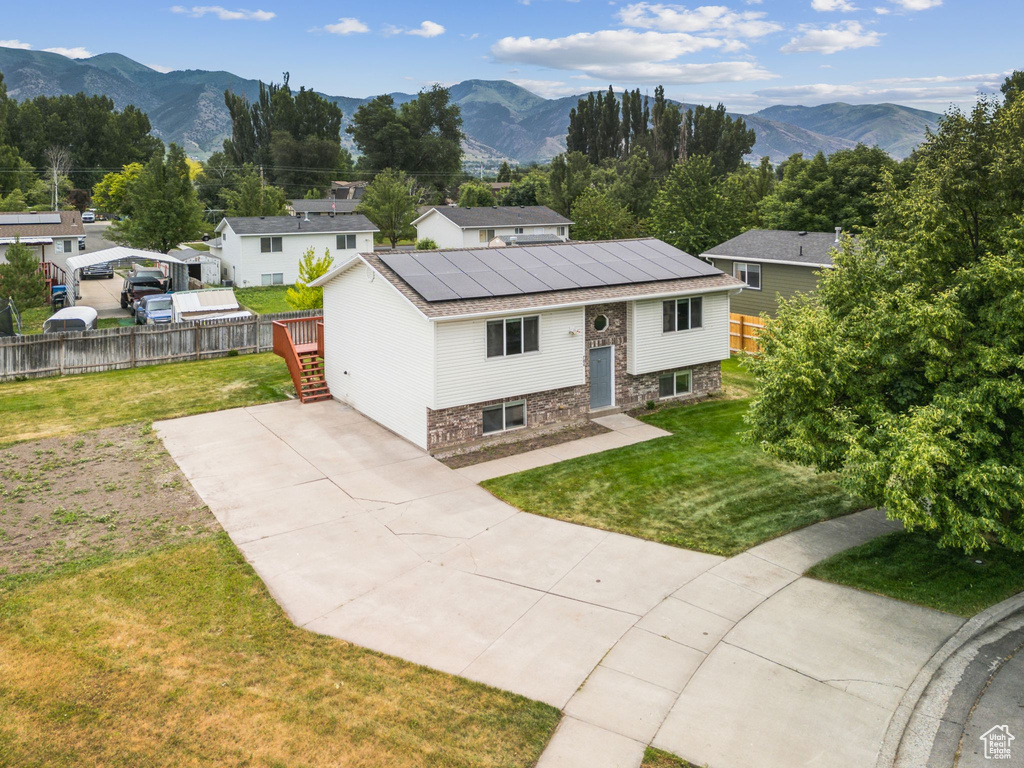 View of front of property with roof mounted solar panels, driveway, and a mountain view