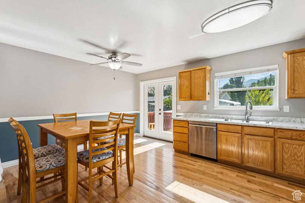 Kitchen featuring stainless steel dishwasher, french doors, plenty of natural light, and light wood-style floors