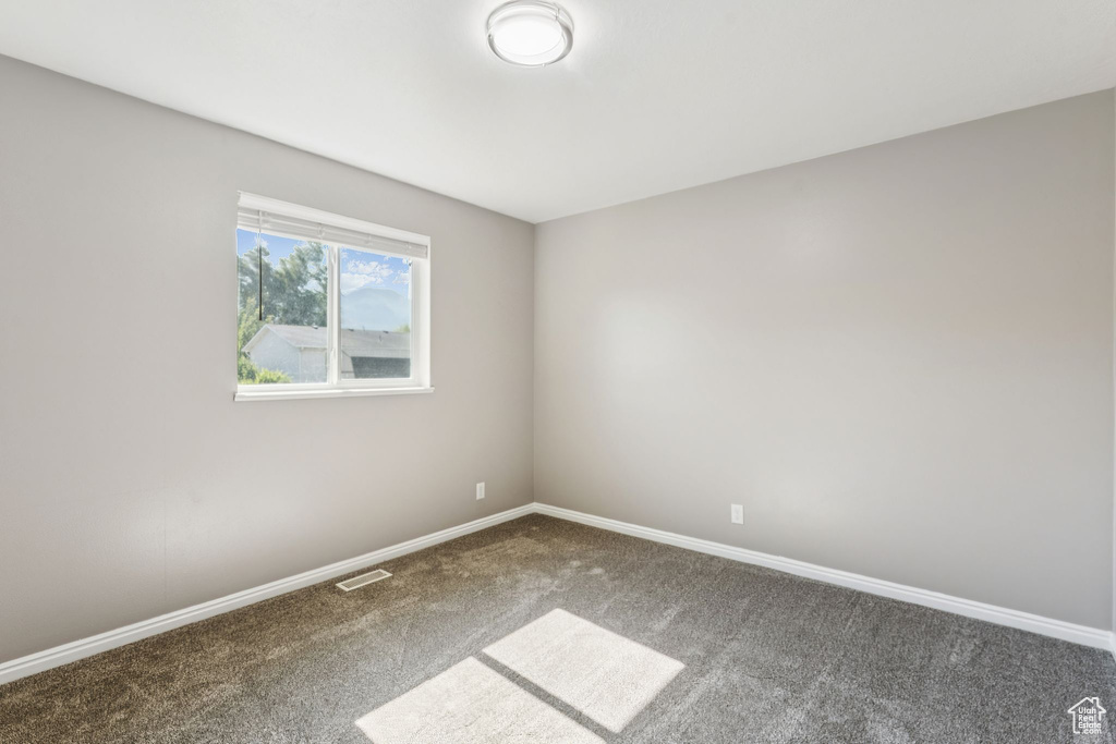 Unfurnished room featuring carpet and baseboards