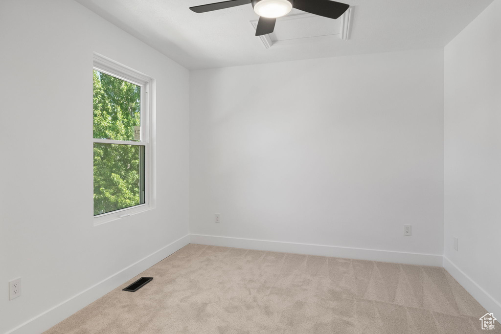 Unfurnished room featuring light colored carpet and a ceiling fan