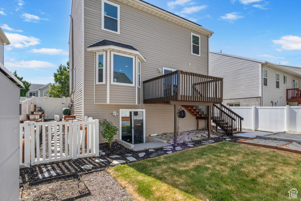 Rear view of property featuring a deck, a fenced backyard, and stairs