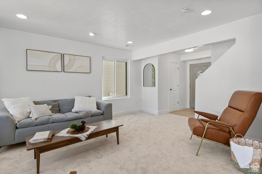 Living area with recessed lighting and light carpet