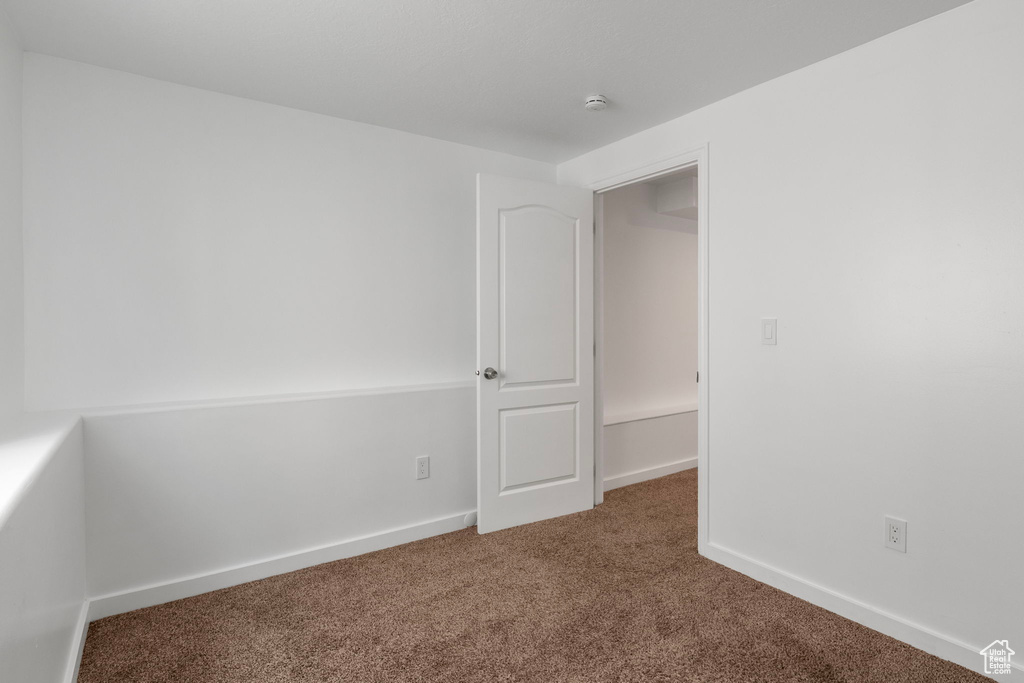 Spare room featuring carpet floors and a smoke detector