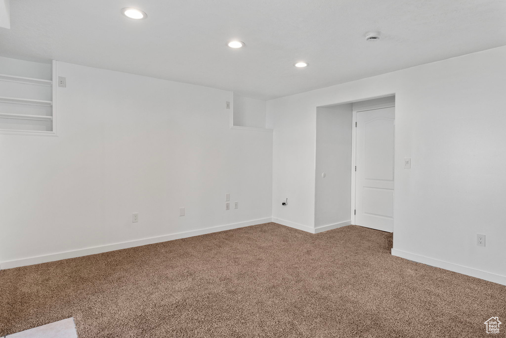 Carpeted empty room with recessed lighting and baseboards