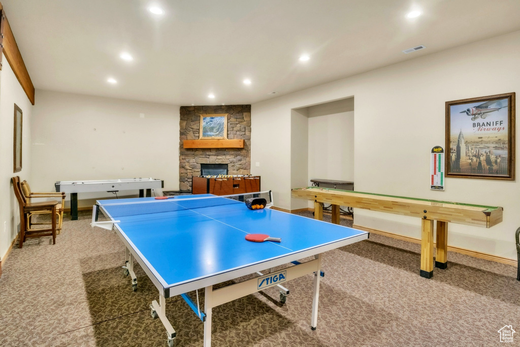 Game room with carpet, recessed lighting, and a stone fireplace