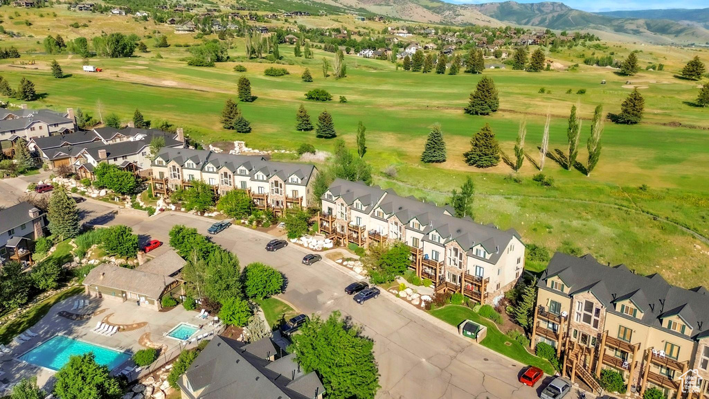 Aerial perspective of suburban area featuring a mountain backdrop and a golf course