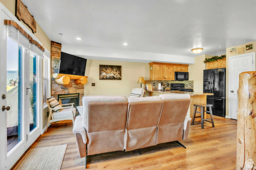 Living room featuring a fireplace, light wood-style floors, and recessed lighting