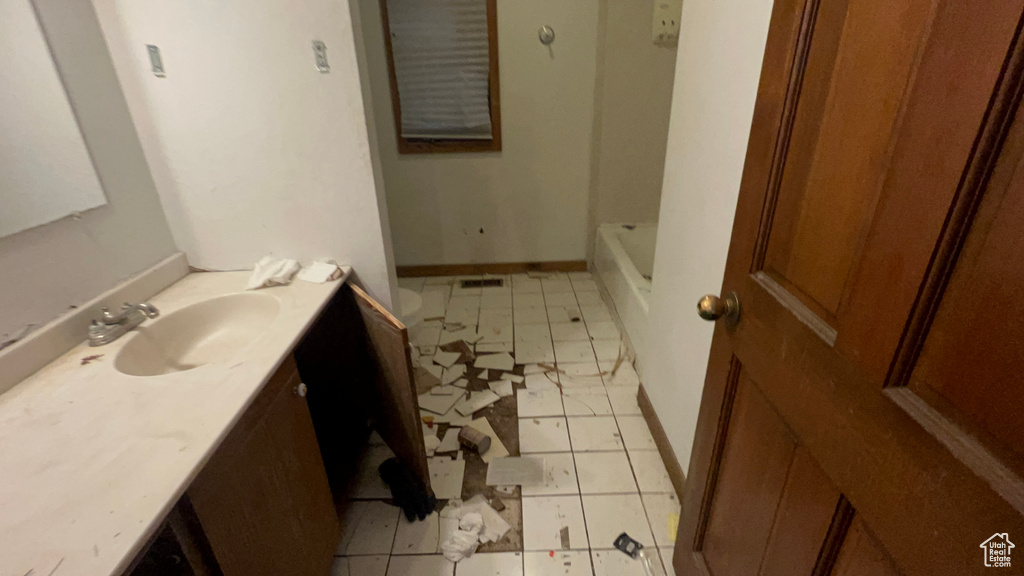 Bathroom featuring vanity, a tub, tile patterned flooring, and a shower