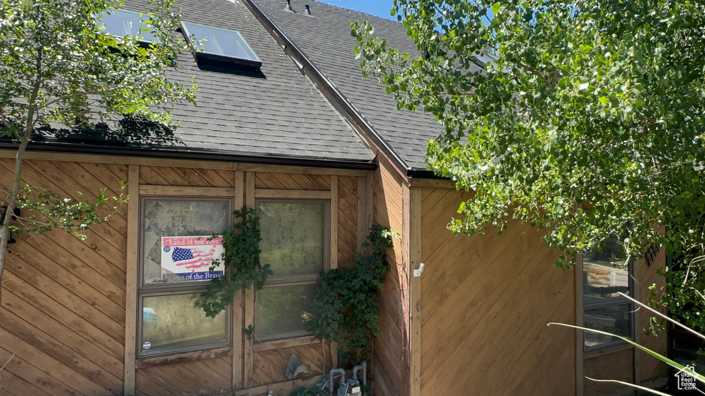 View of side of property featuring a shingled roof