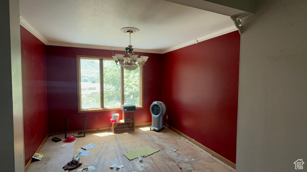 Spare room featuring a chandelier and ornamental molding