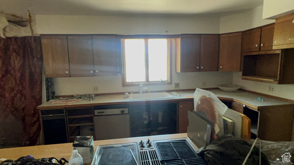 Kitchen featuring dishwashing machine and light countertops