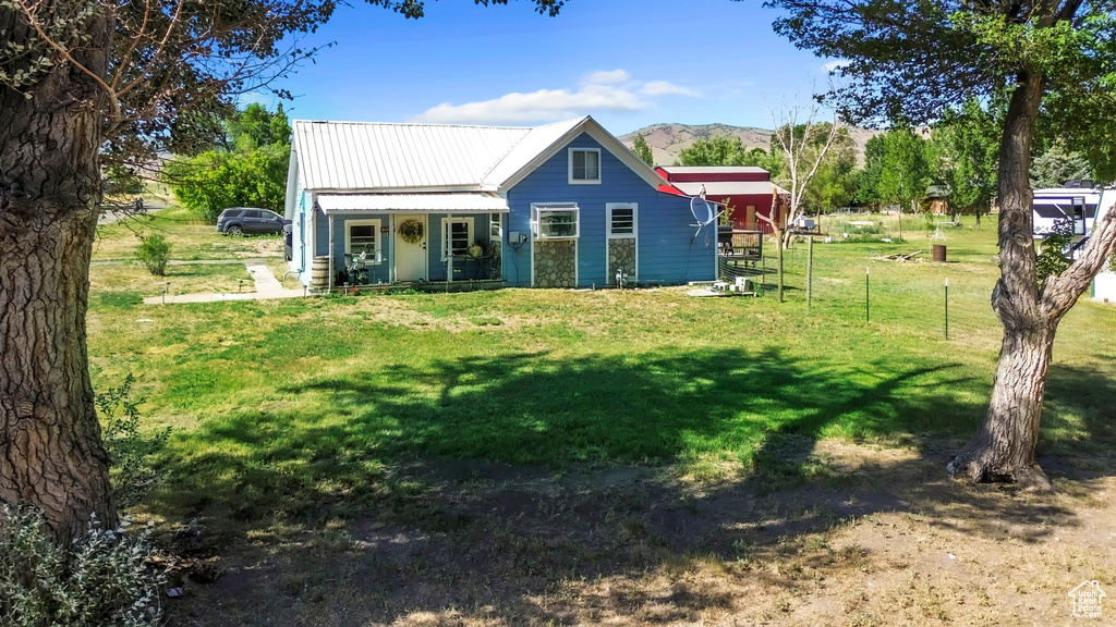 Back of property featuring a porch, a metal roof, and a mountain view