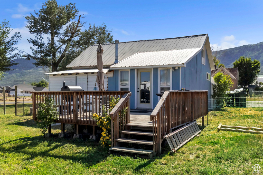 Rear view of property featuring a deck with mountain view and a metal roof