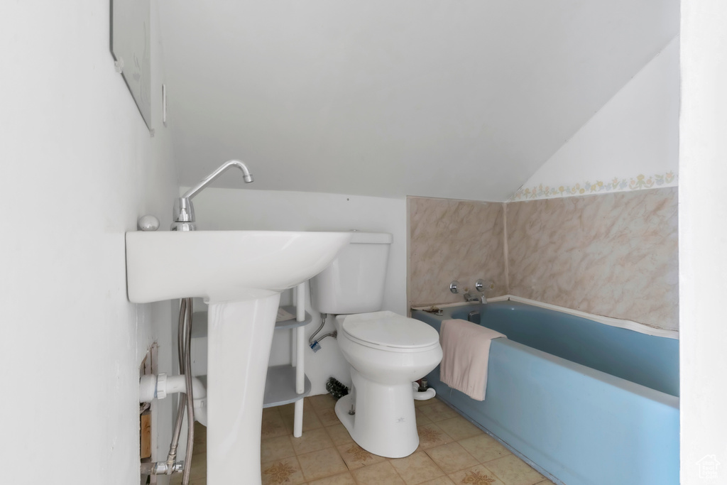 Bathroom featuring a garden tub and lofted ceiling