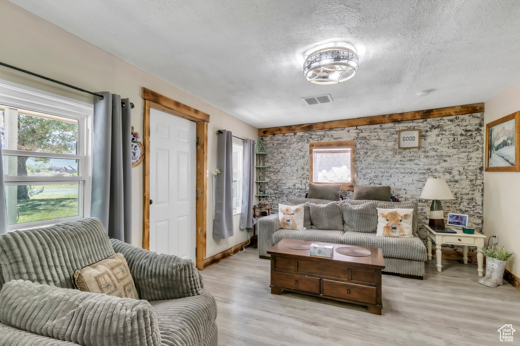 Living area with a textured ceiling and light wood-type flooring