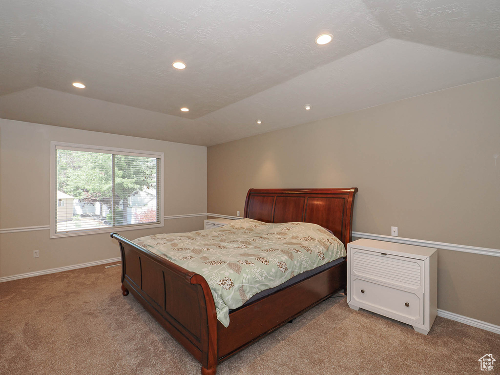 Bedroom featuring light carpet, vaulted ceiling, and recessed lighting