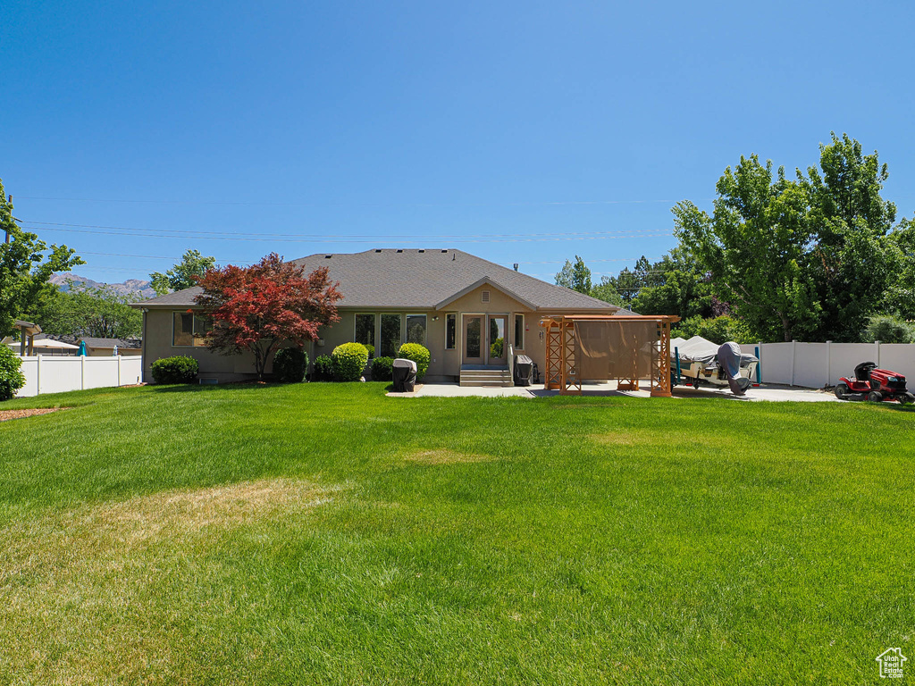 Rear view of property featuring a patio area and a fenced backyard