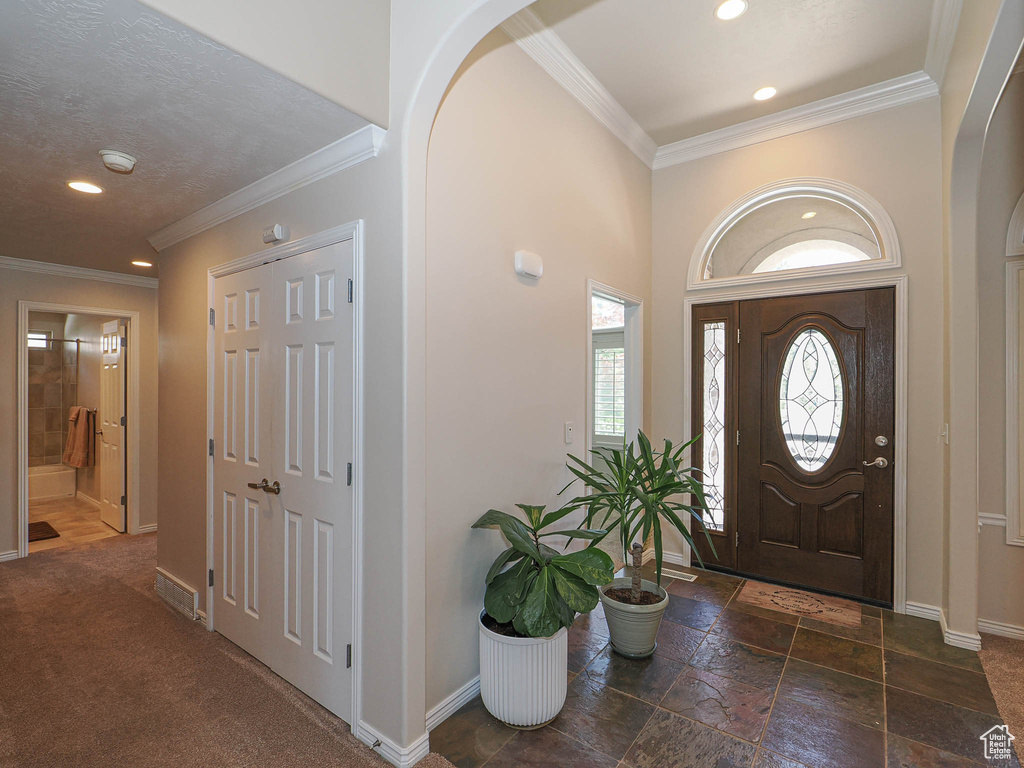 Foyer featuring recessed lighting, ornamental molding, and stone tile floors