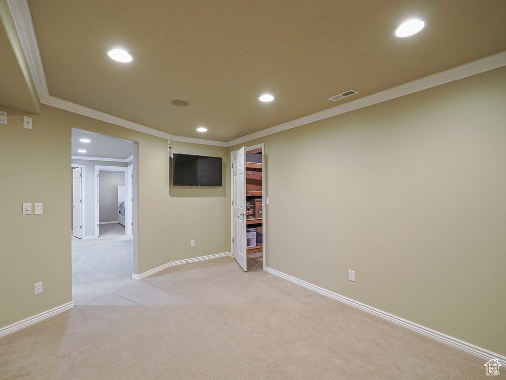 Below grade area featuring recessed lighting, ornamental molding, and light colored carpet