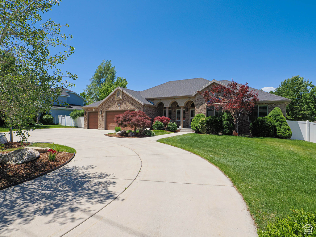 View of front of home featuring curved driveway, a garage, stone siding, and brick siding