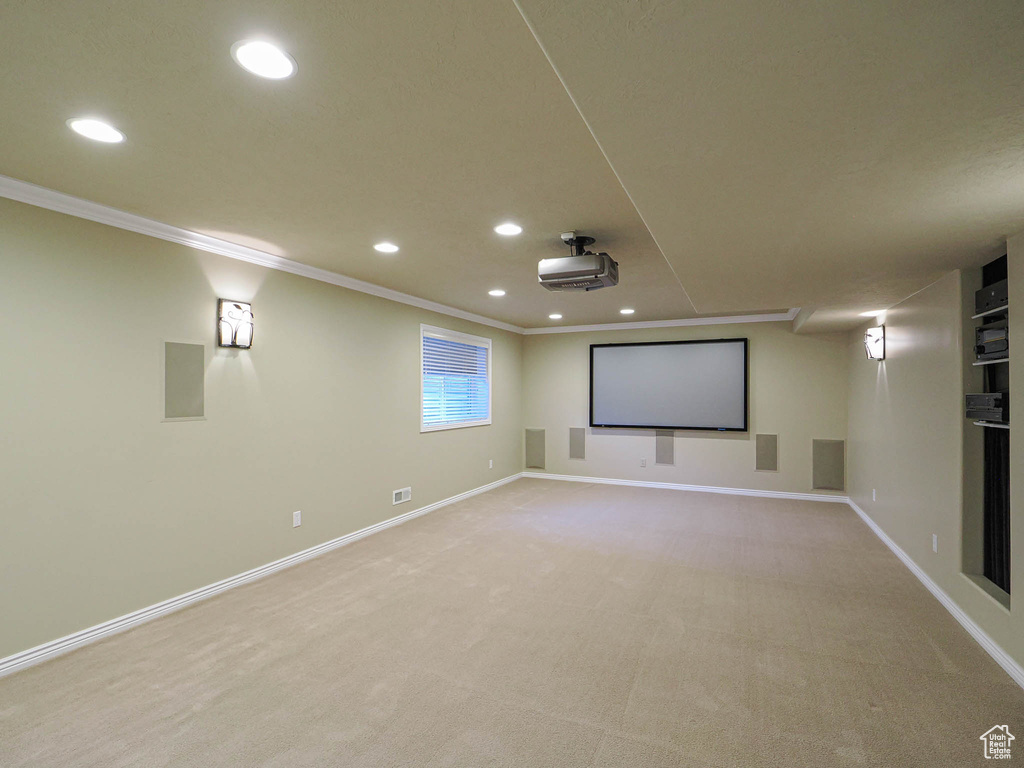 Home theater with crown molding, recessed lighting, and light carpet