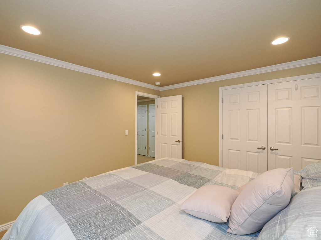 Bedroom featuring recessed lighting, ornamental molding, and a closet