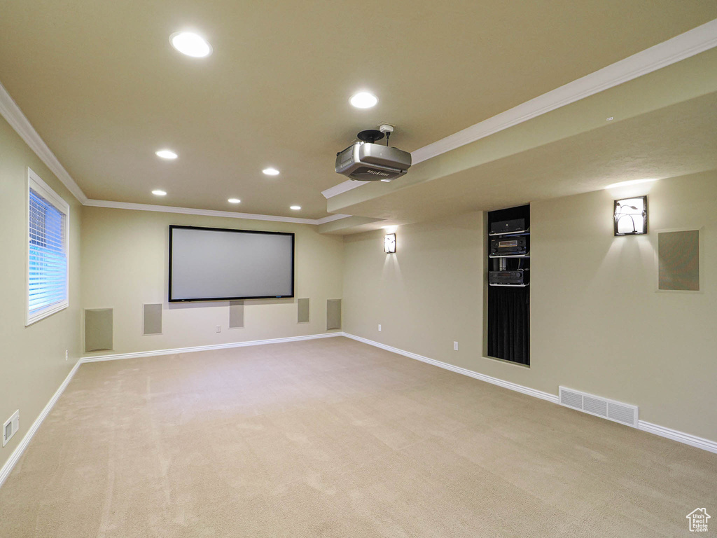 Home theater with crown molding, recessed lighting, and light colored carpet