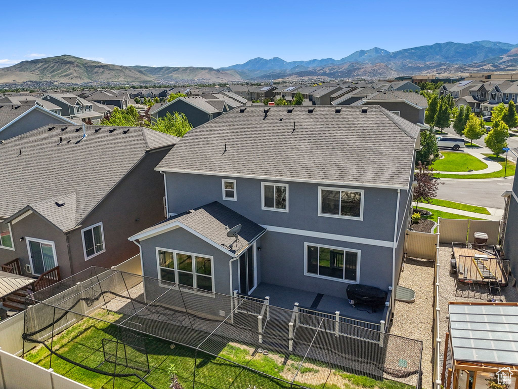 Rear view of house featuring a residential view, stucco siding, roof with shingles, and a mountain view