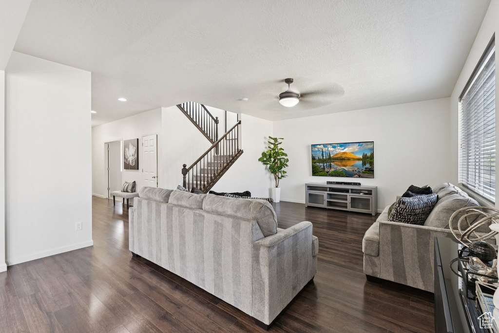 Living area with stairs, dark wood-type flooring, a ceiling fan, recessed lighting, and a textured ceiling