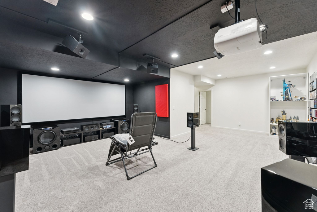 Carpeted cinema room with recessed lighting and baseboards