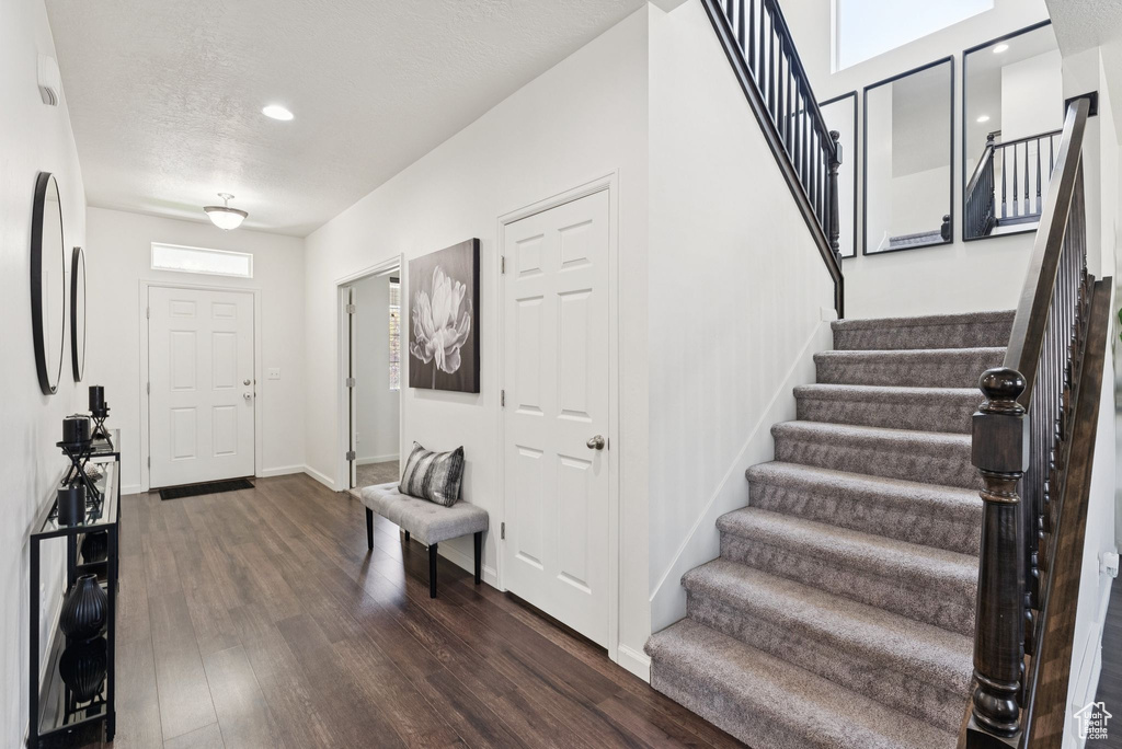 Entrance foyer featuring stairs, dark wood-style floors, and recessed lighting