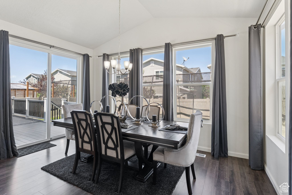 Dining room with lofted ceiling, a chandelier, and dark wood-style flooring