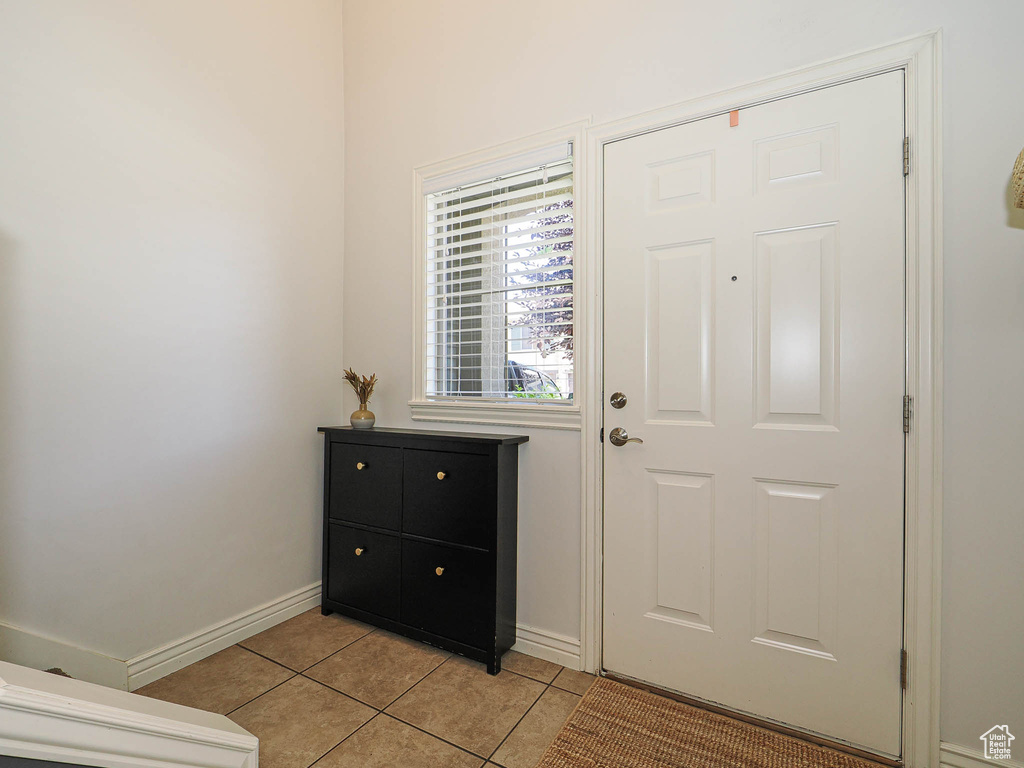Entryway with light tile patterned floors and baseboards